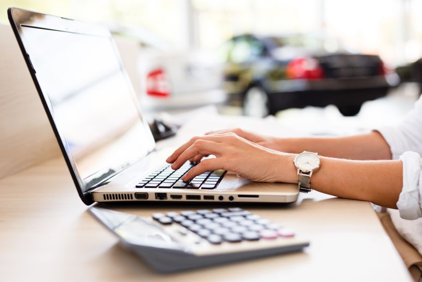 Frau im Autohaus am Notebook