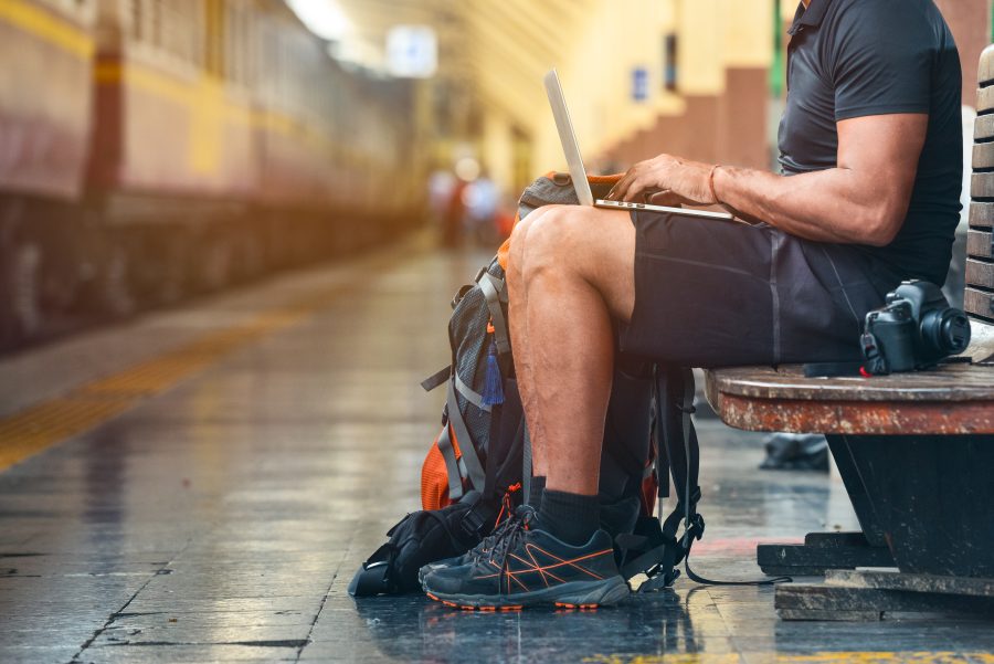 digitaler Nomade mit Notebook an Bahnsteig