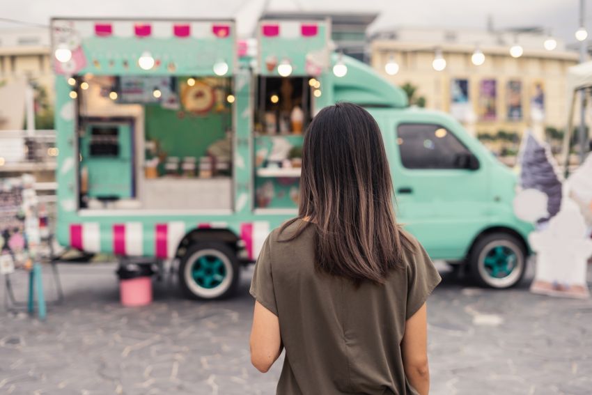 Frau steht vor Food-Truck