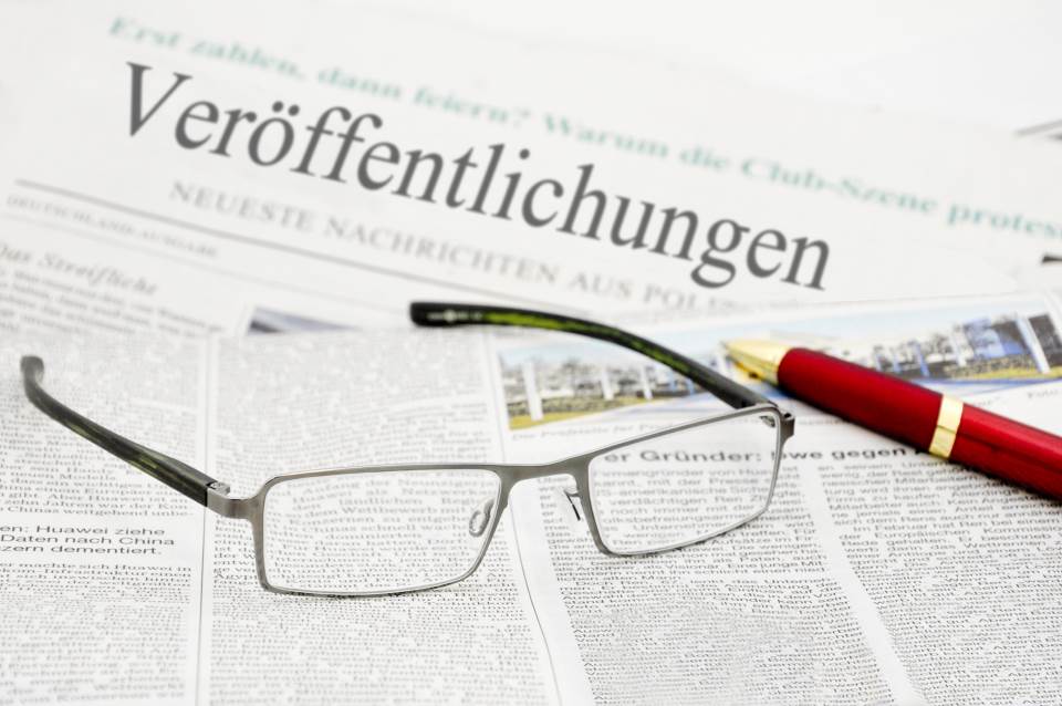 Brille und Stift auf Zeitung