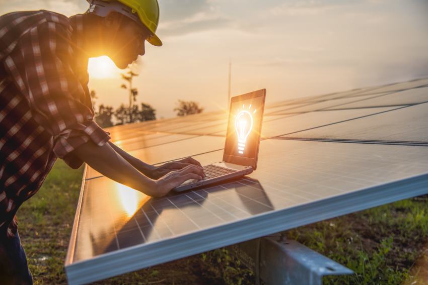 Umweltingenieur mit Laptop vor Solarfeld